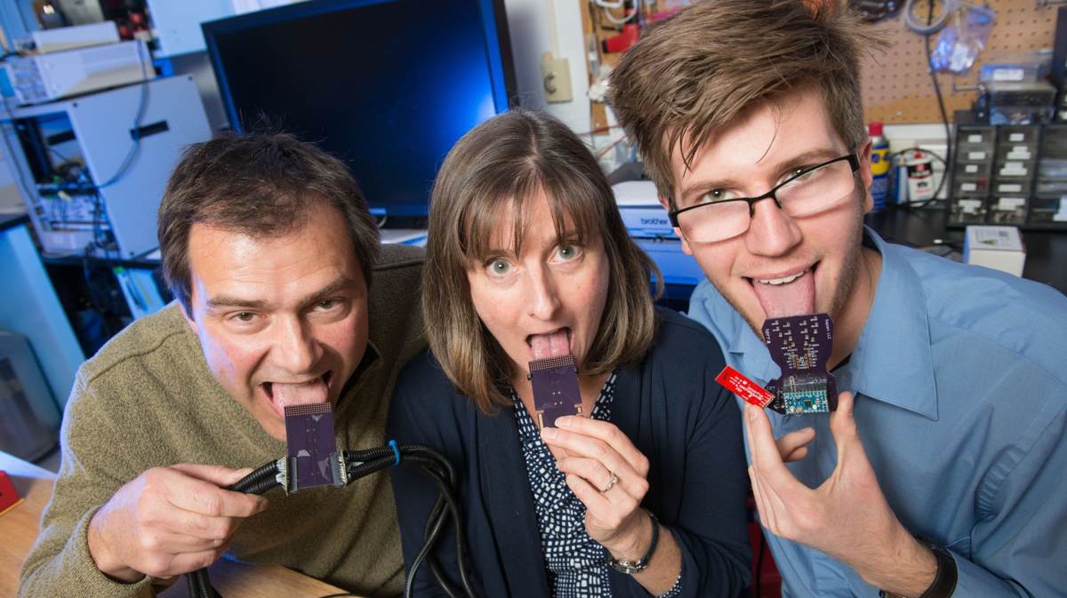 El Dr. John Williams, profesor de ingeniería mecánica; la Dra. Leslie Stone-Roy, profesora de neurociencia; y J J  Moritz, estudiante licenciado, están desarrollando un dispositivo para escuchar a través de la lengua.